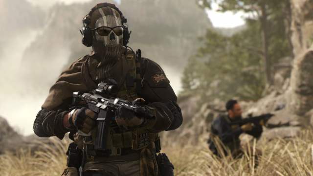 A soldier wearing a ghost mask stands near a squadmate in the long grass in Call of Duty: Modern Warfare.